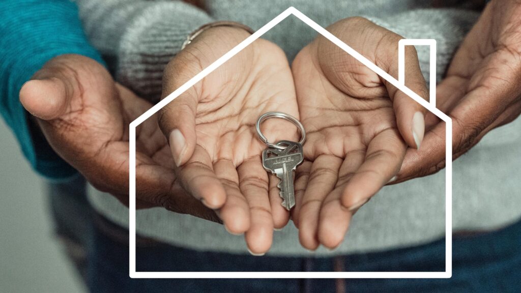 Hands of a couple holding a house key symbolizing home ownership and new beginnings.